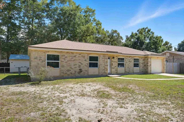a view of a yard in front of a house with large tree