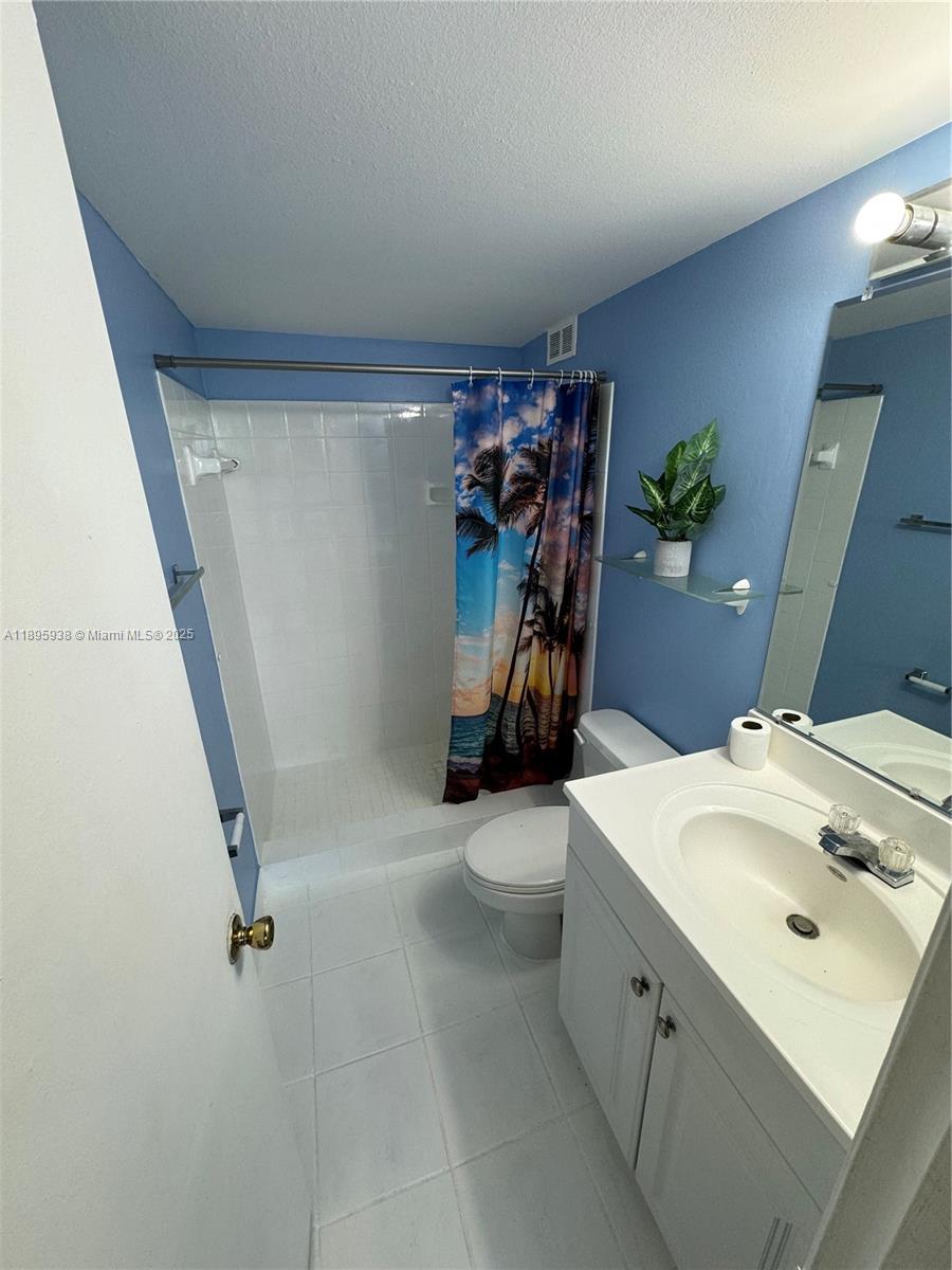 1251 Northeast 108th Street, Unit 602 Miami, FL 33161 - Photo 11 of 11 a bathroom with a sink a toilet and shower