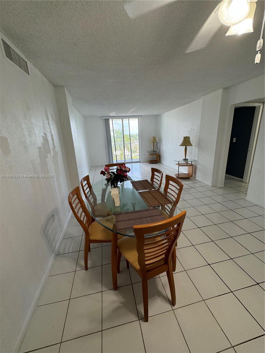 1251 Northeast 108th Street, Unit 602 Miami, FL 33161 - Photo 2 of 11 a table and chairs in a room