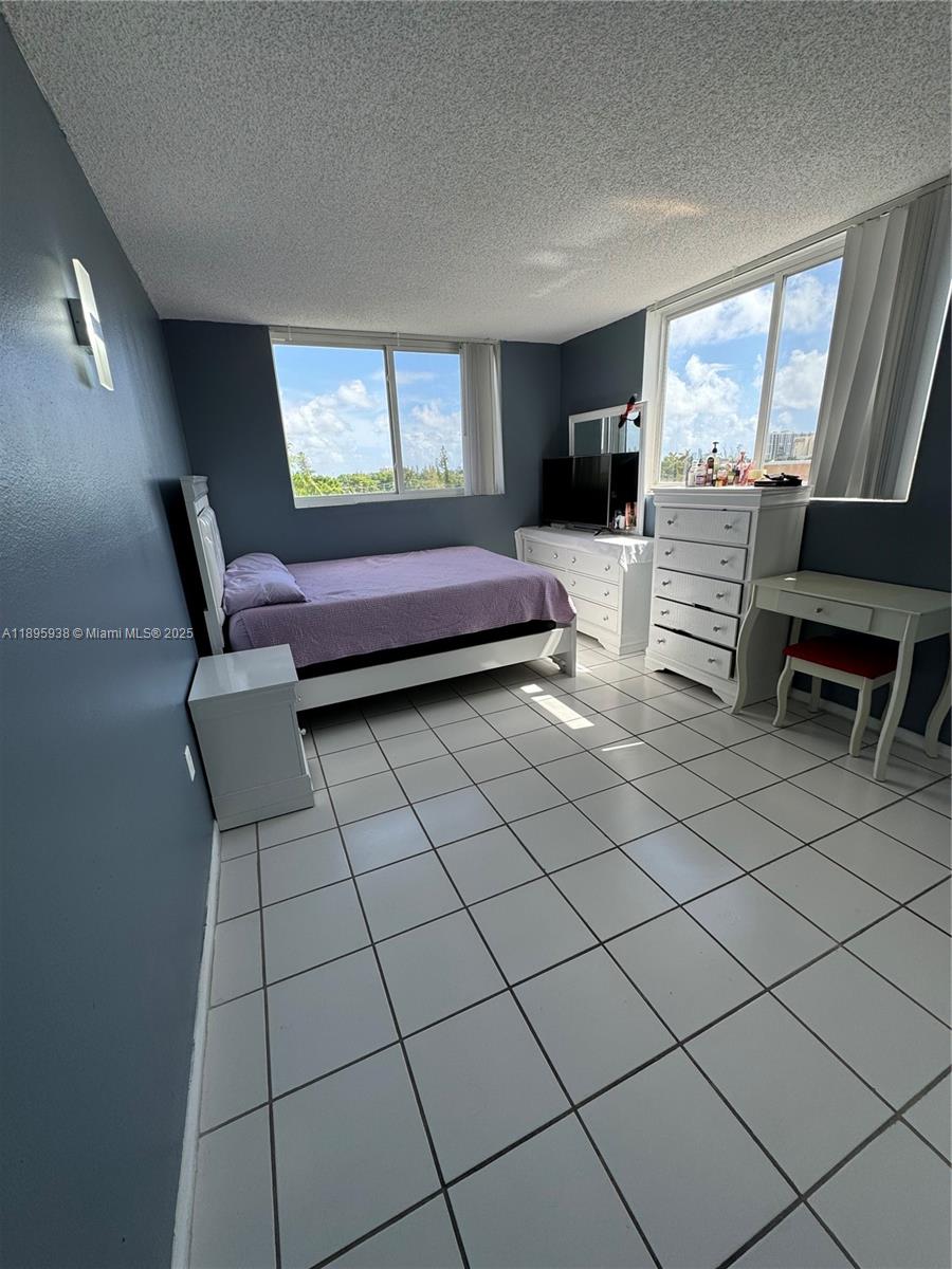 1251 Northeast 108th Street, Unit 602 Miami, FL 33161 - Photo 6 of 11 a bedroom with furniture and a window