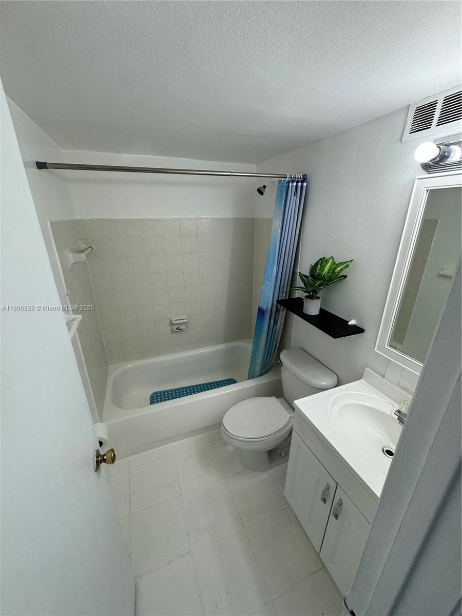 1251 Northeast 108th Street, Unit 602 Miami, FL 33161 - Photo 8 of 11 a bathroom with a sink a toilet and shower