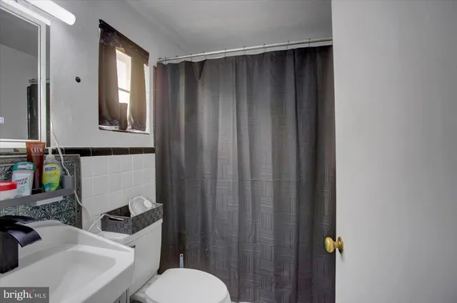 a bedroom with bed and a refrigerator