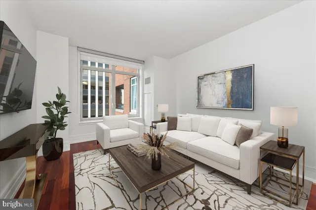 a living room with furniture a flat screen tv and a large window