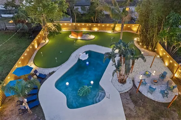 an aerial view of a house with swimming pool and outdoor space