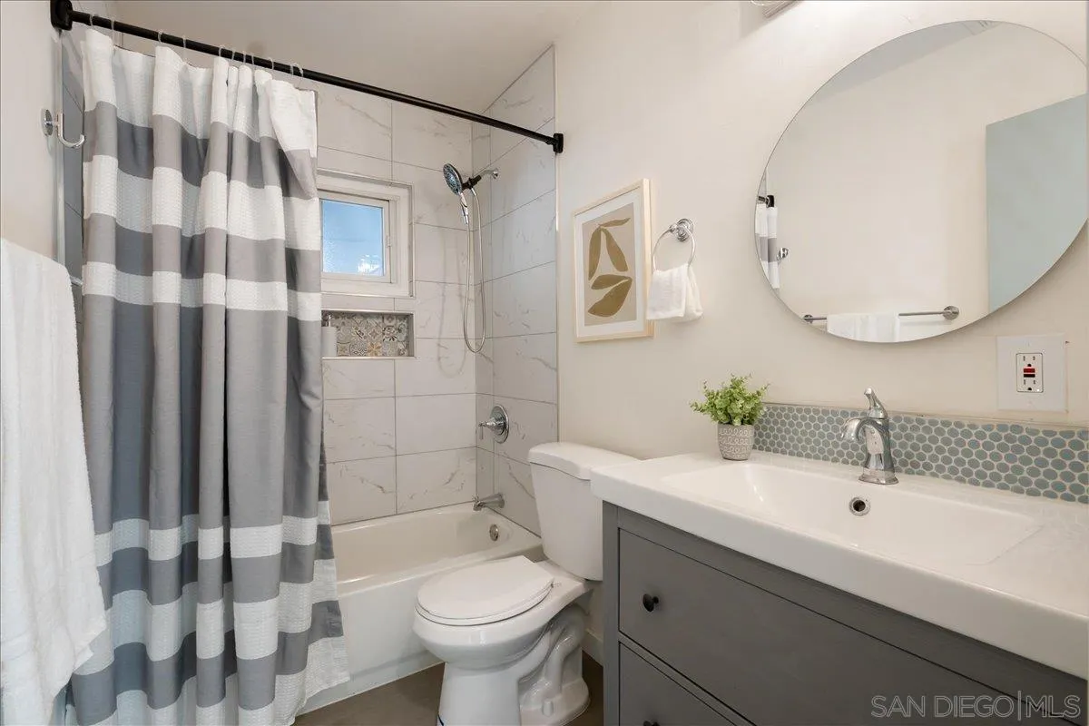 941 8th Street Imperial Beach, CA 91932 - Photo 13 of 22 a bathroom with a sink toilet a mirror and shower