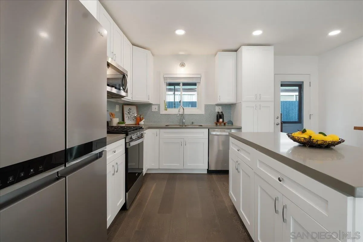 941 8th Street Imperial Beach, CA 91932 - Photo 8 of 22 a kitchen with a sink stainless steel appliances white cabinets and a window