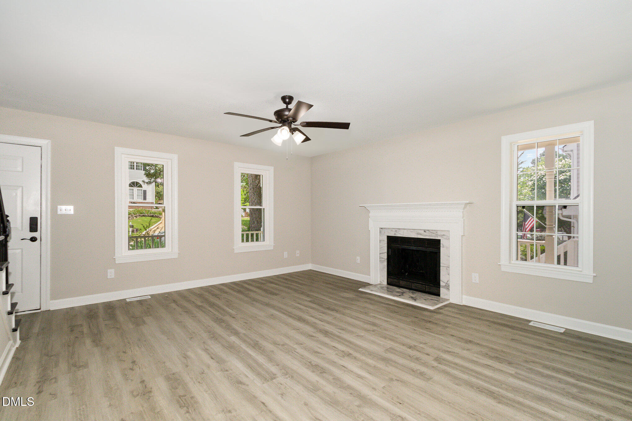 2324 Dahlgreen Road Raleigh, NC 27615 - Photo 4 of 21 an empty room with windows fireplace and wooden floor