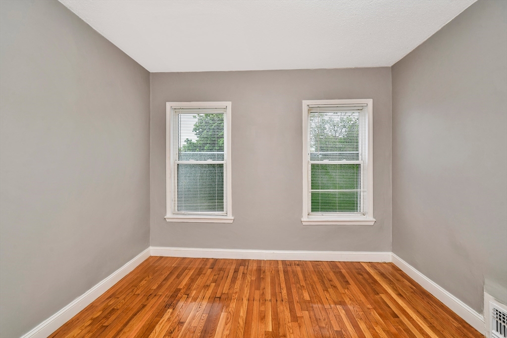352 Norfolk Street, Unit 3 Boston, MA 02124 - Photo 8 of 12 an empty room with wooden floor and windows