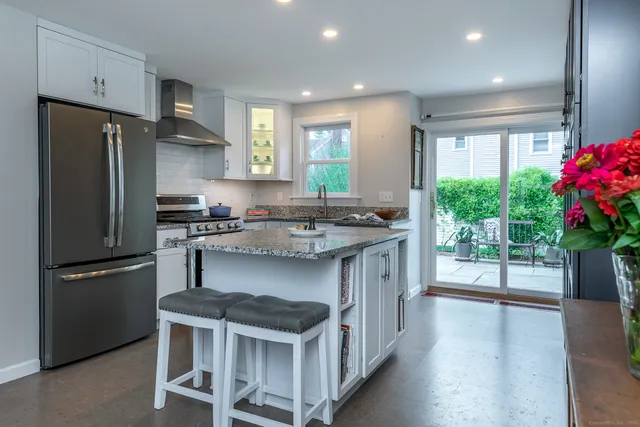 a kitchen with kitchen island a counter space a stove and a refrigerator