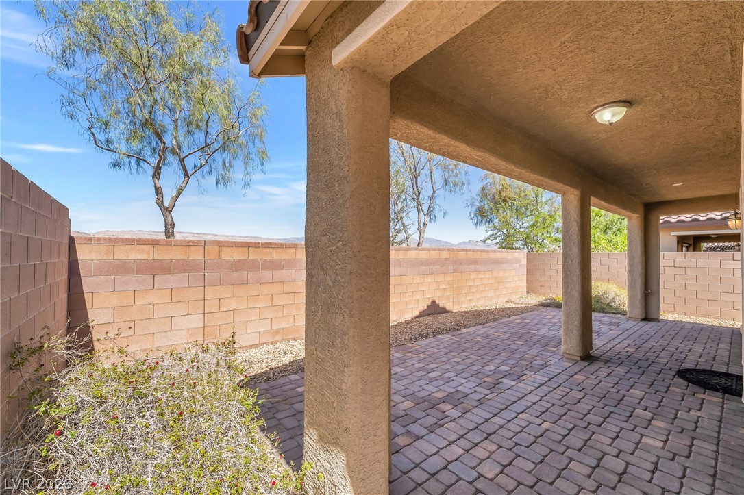 6245 Andover Wood Road Las Vegas, NV 89113 - Photo 31 of 37 A spacious covered patio with paver flooring provides a comfortable outdoor living area.