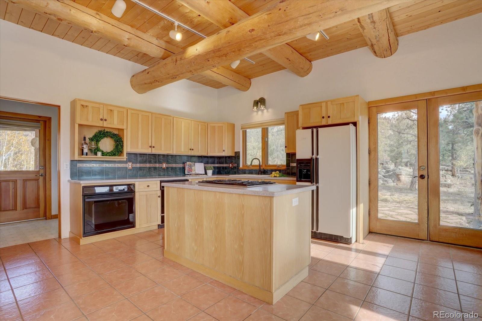 12227 Calfee Gulch Road Conifer, CO 80433 - Photo 15 of 43 a large white kitchen with a stove a refrigerator and a stove top oven