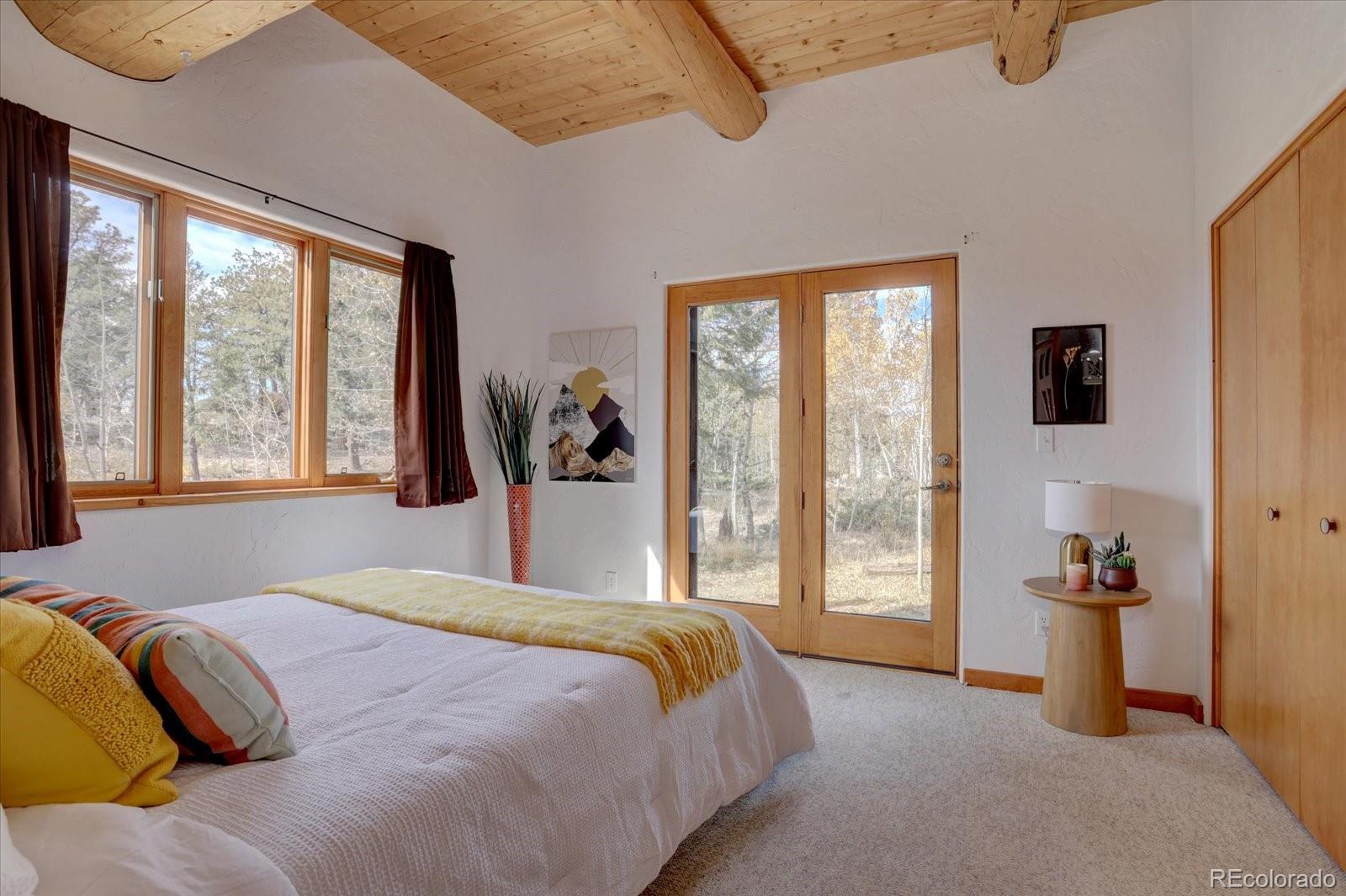 12227 Calfee Gulch Road Conifer, CO 80433 - Photo 16 of 43 a bedroom with a large bed and a large window