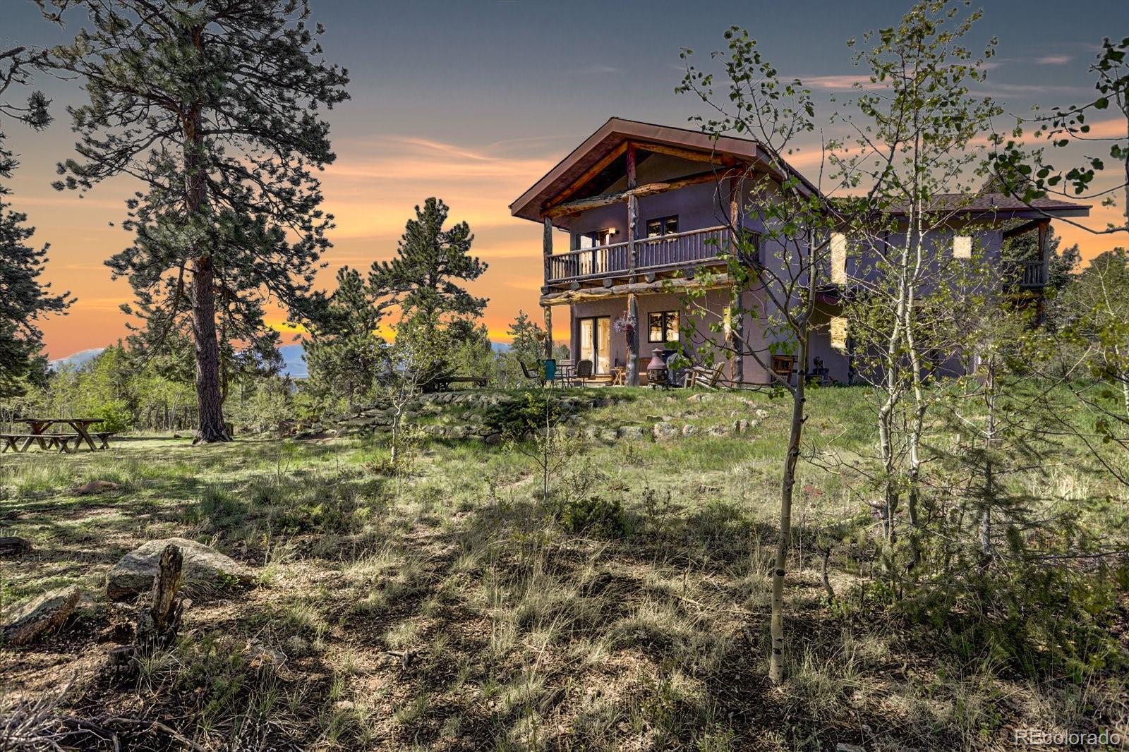 12227 Calfee Gulch Road Conifer, CO 80433 - Photo 2 of 43 a front view of a house with a yard