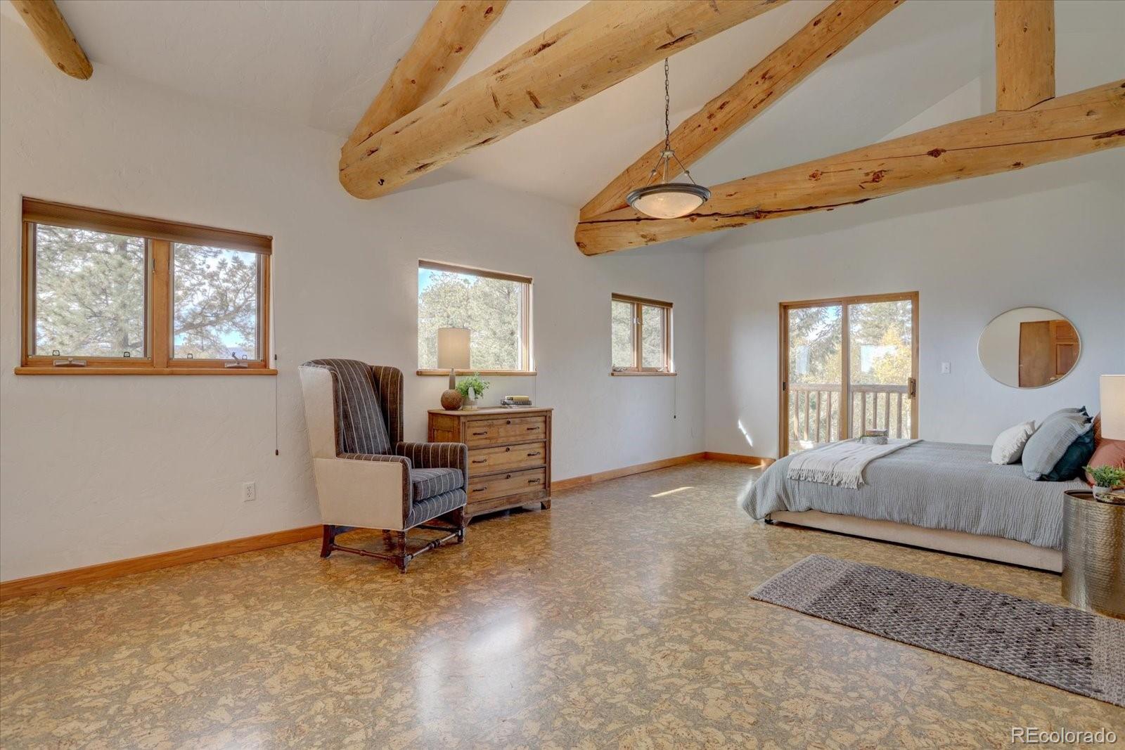 12227 Calfee Gulch Road Conifer, CO 80433 - Photo 25 of 43 a bedroom with furniture and windows