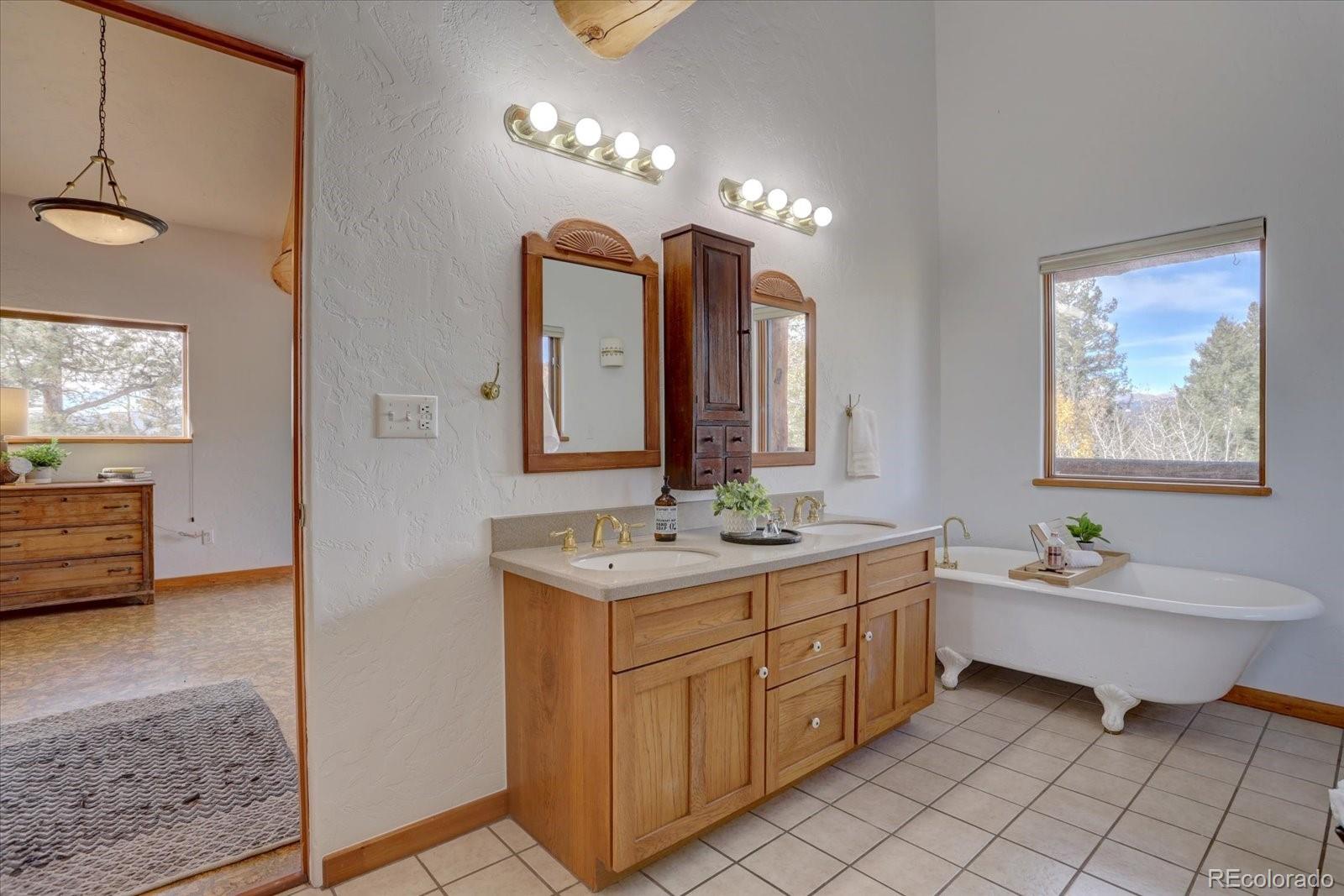 12227 Calfee Gulch Road Conifer, CO 80433 - Photo 27 of 43 a spacious bathroom with a double vanity sink mirror and bathtub