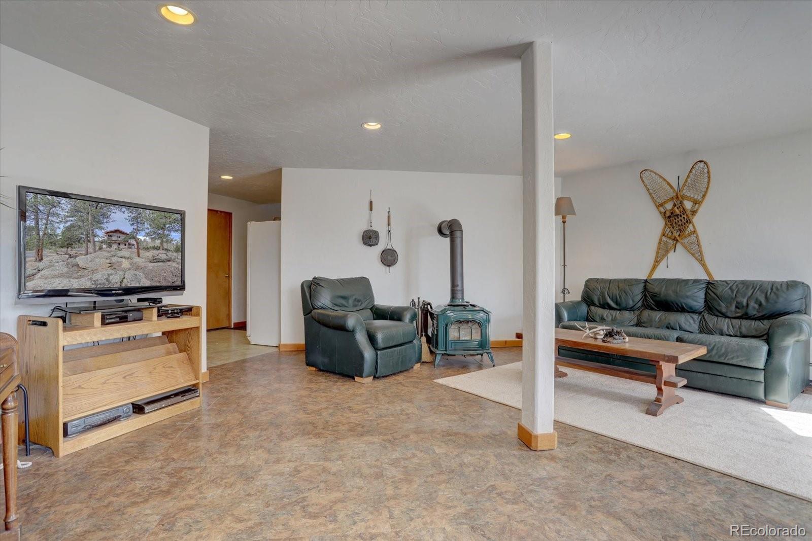 12227 Calfee Gulch Road Conifer, CO 80433 - Photo 29 of 43 a living room with furniture and a flat screen tv