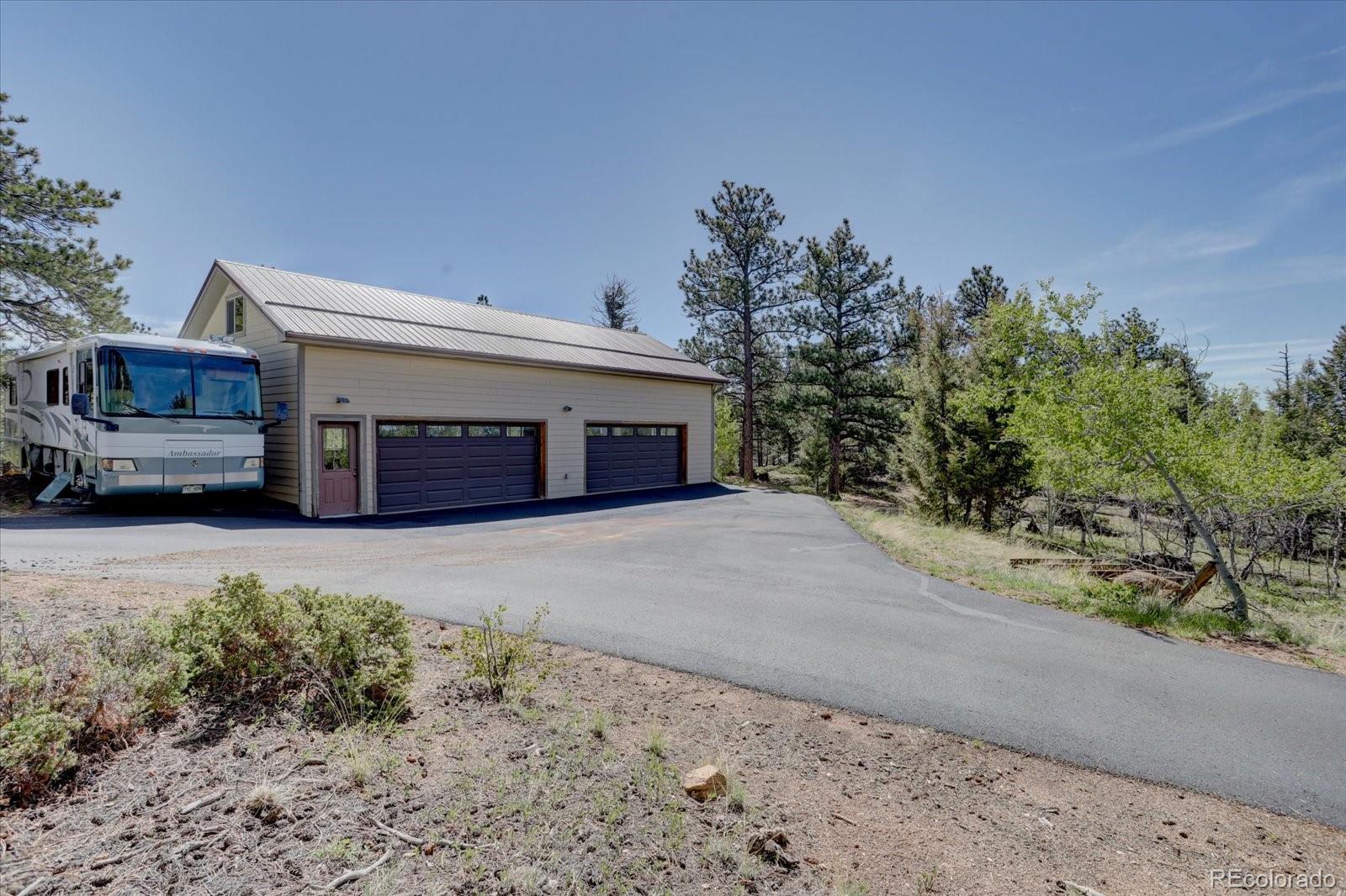 12227 Calfee Gulch Road Conifer, CO 80433 - Photo 32 of 43 a front view of a house with a yard