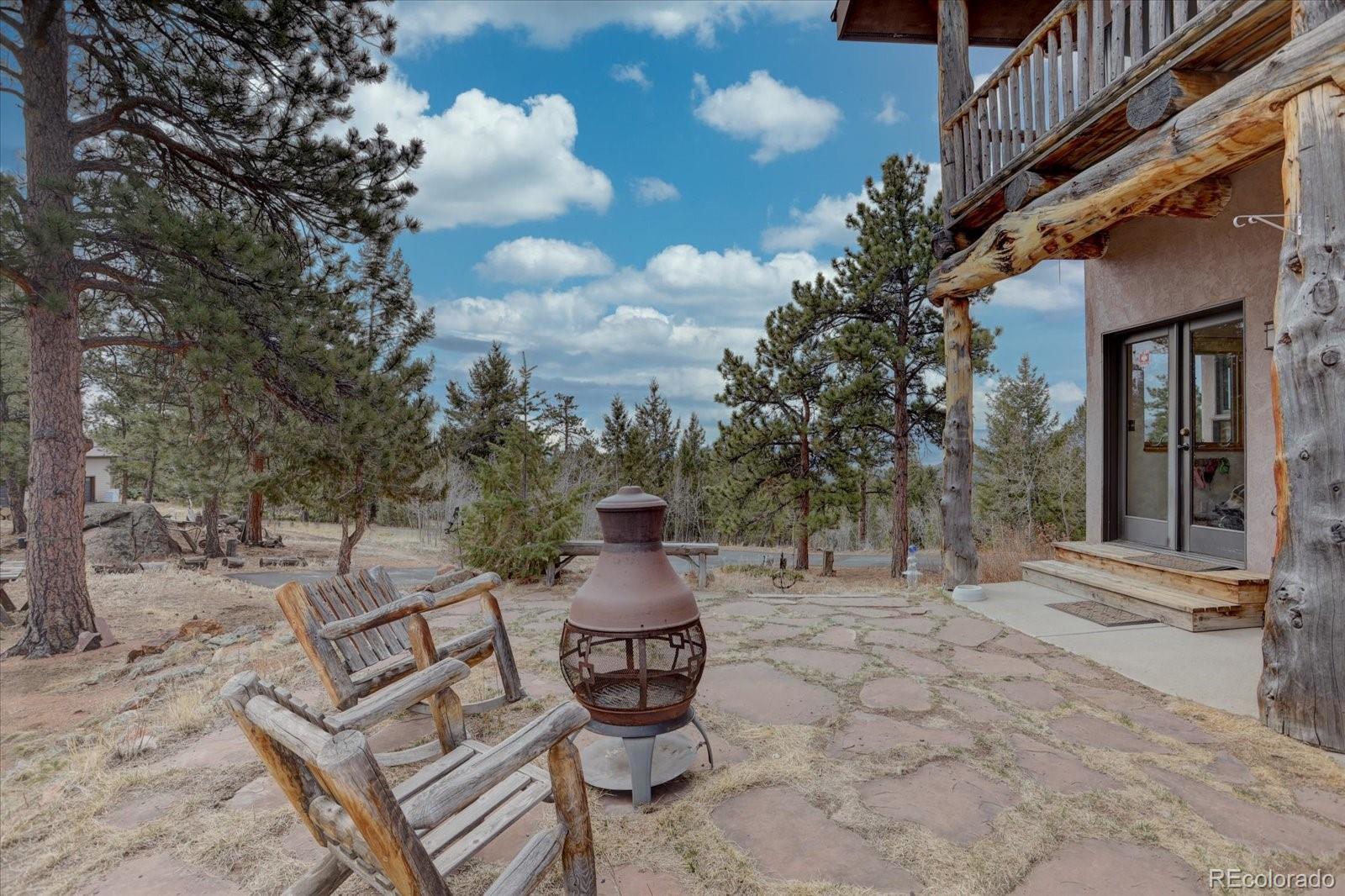 12227 Calfee Gulch Road Conifer, CO 80433 - Photo 33 of 43 a backyard of a house with table and chairs