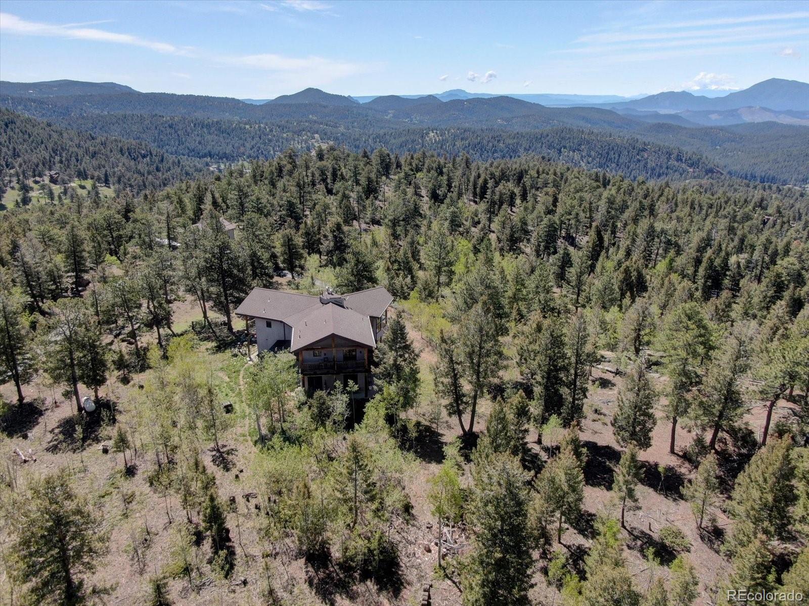 12227 Calfee Gulch Road Conifer, CO 80433 - Photo 42 of 43 a view of a lush green hillside and a houses