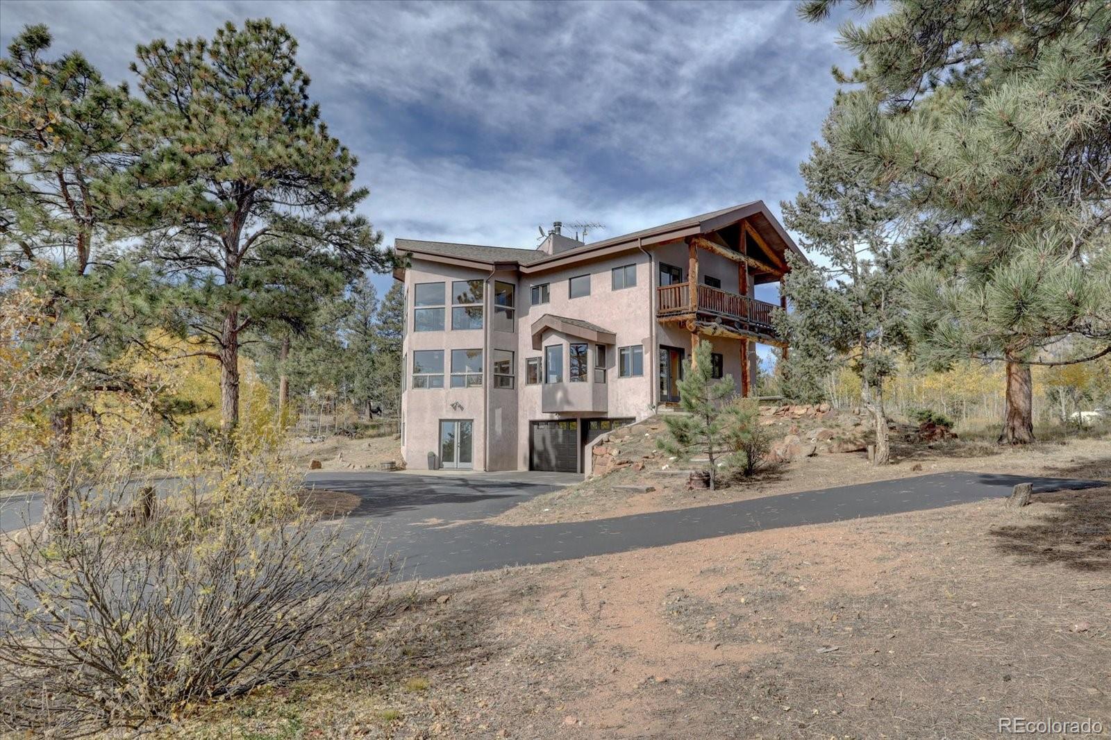 12227 Calfee Gulch Road Conifer, CO 80433 - Photo 6 of 43 front view of a house with a street