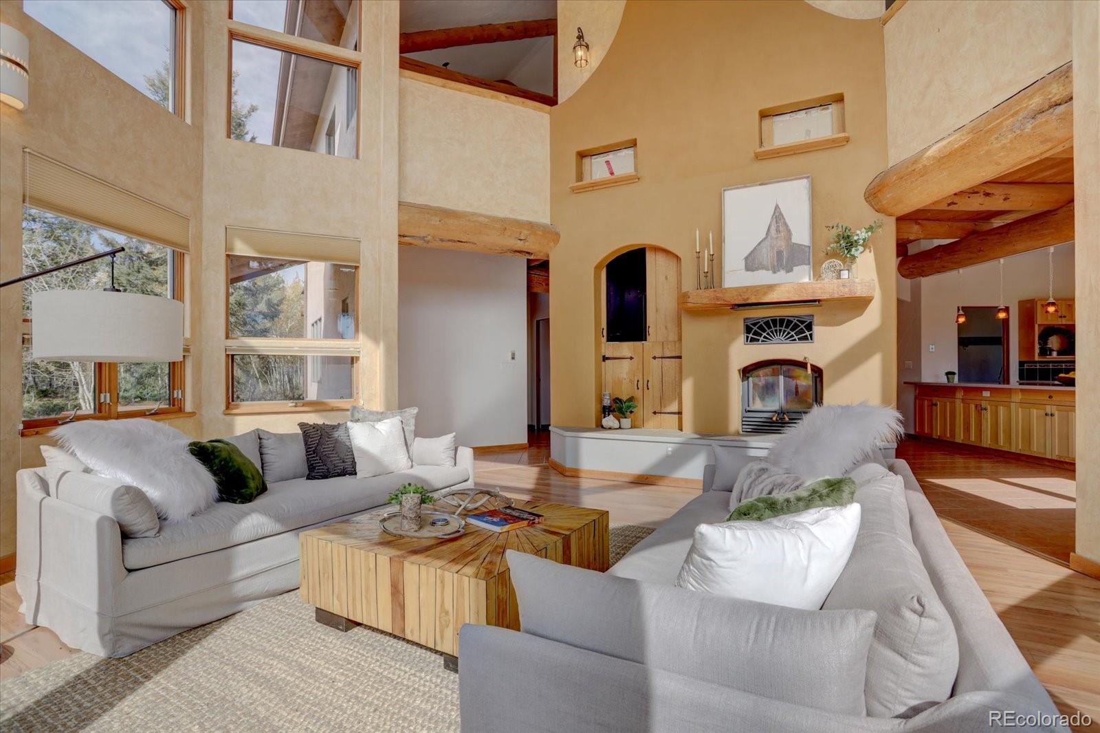 12227 Calfee Gulch Road Conifer, CO 80433 - Photo 7 of 43 a living room with furniture fireplace and a table