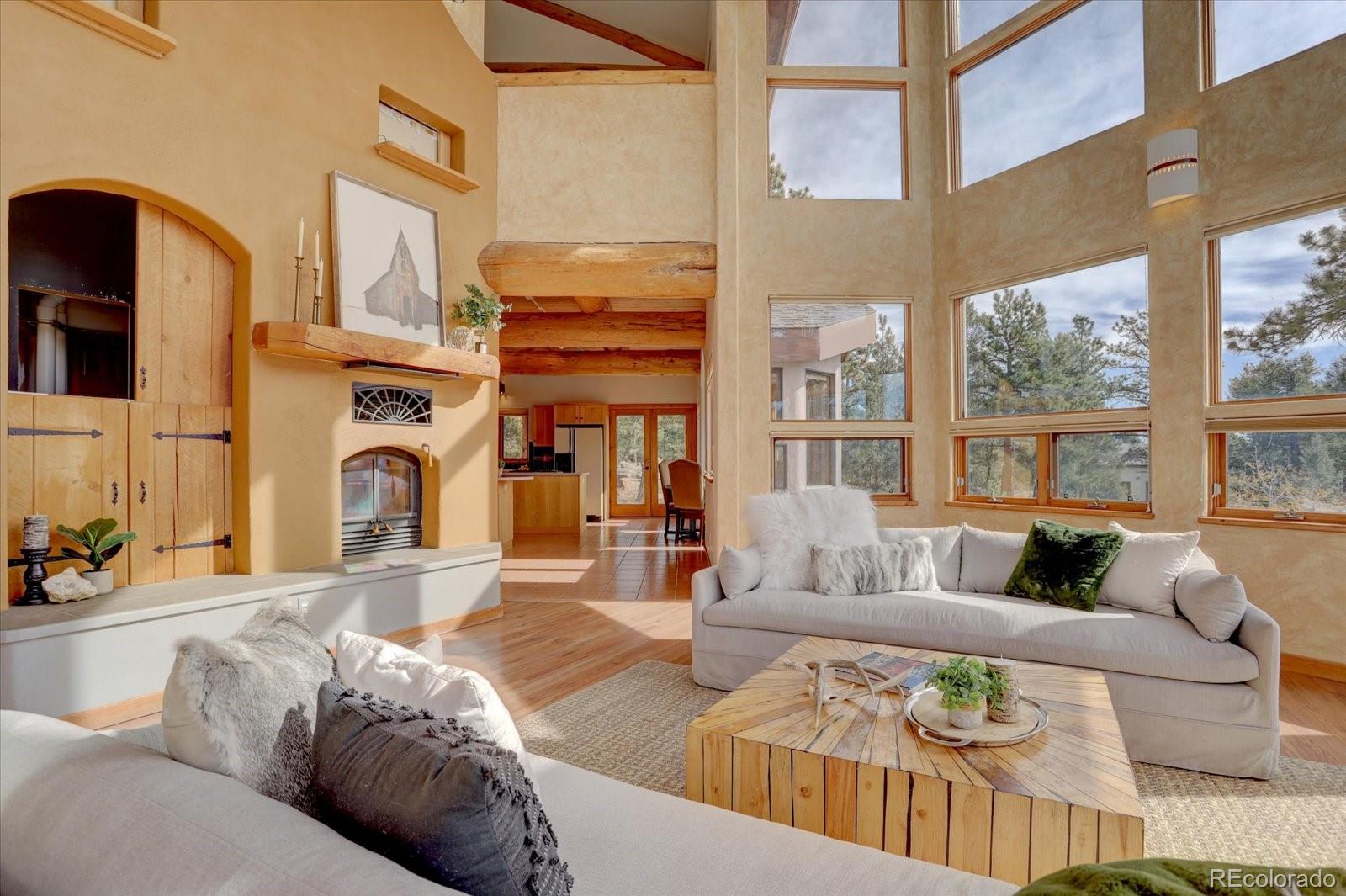 12227 Calfee Gulch Road Conifer, CO 80433 - Photo 8 of 43 a living room with fireplace furniture and a large window