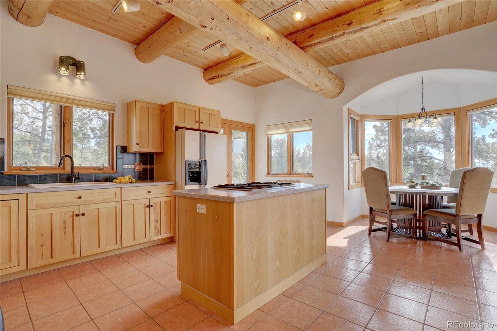 12227 Calfee Gulch Road Conifer, CO 80433 - Photo 10 of 43 a large kitchen with kitchen island granite countertop a large island in the center