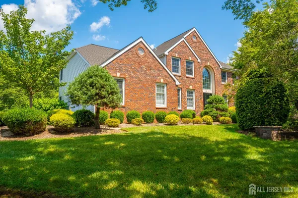 a front view of a house with a yard and trees
