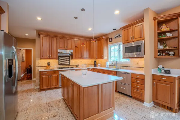 a kitchen with stainless steel appliances granite countertop a sink a stove top oven a counter space and cabinets