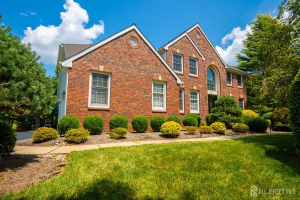 a front view of a house with a yard and plants