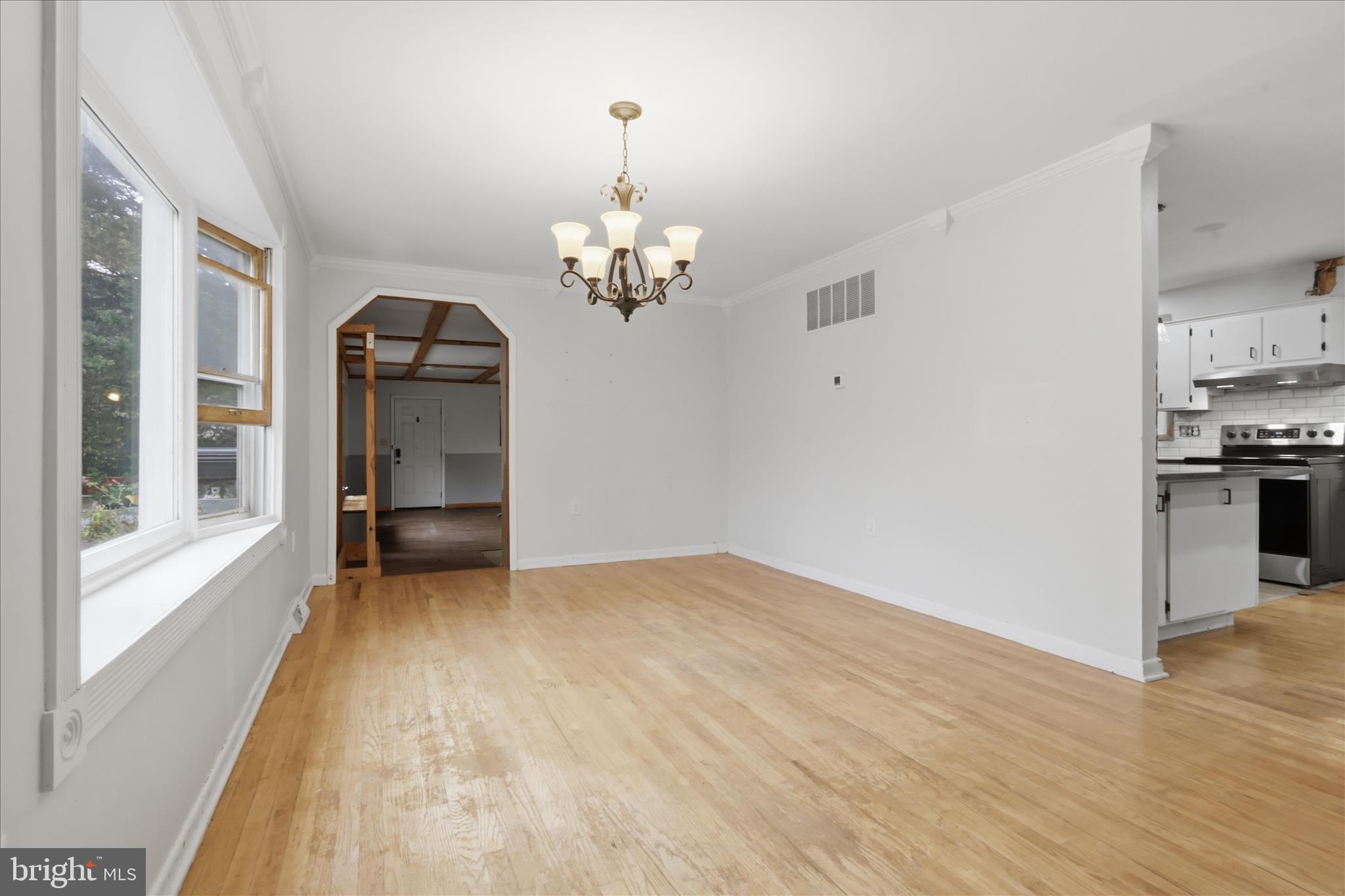 9304 Liberty Court Frederick, MD 21701 - Photo 13 of 49 a view of empty room with wooden floor and kitchen view