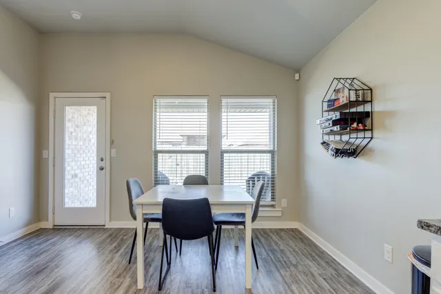 a view of a dining room with furniture a rug and wooden floor