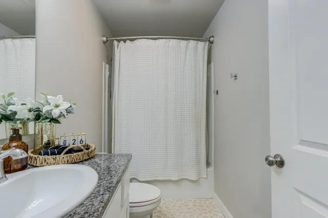 a bathroom with a granite countertop sink toilet and shower