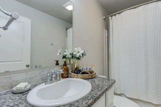 a bathroom with a granite countertop sink a toilet and a mirror
