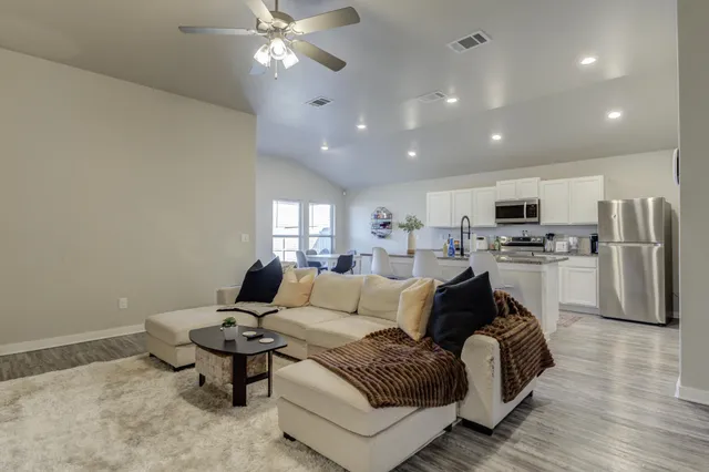 a living room with furniture and kitchen view