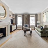 a living room with furniture a mirror and a fireplace