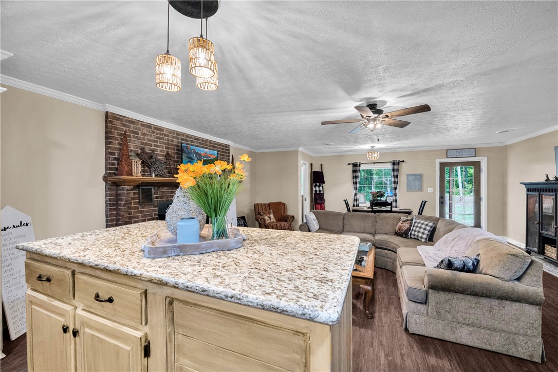 3030 Smith McGee Road Iva, SC 29655 - Photo 22 of 46 Granite counters and rich wood flooring elevate this open-concept living space.