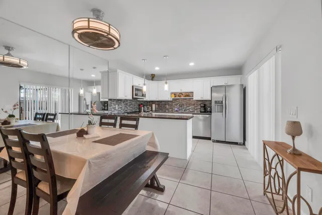a kitchen with a dining table chairs sink and cabinets
