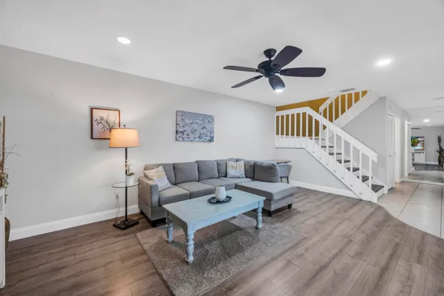 a living room with furniture and a wooden floor