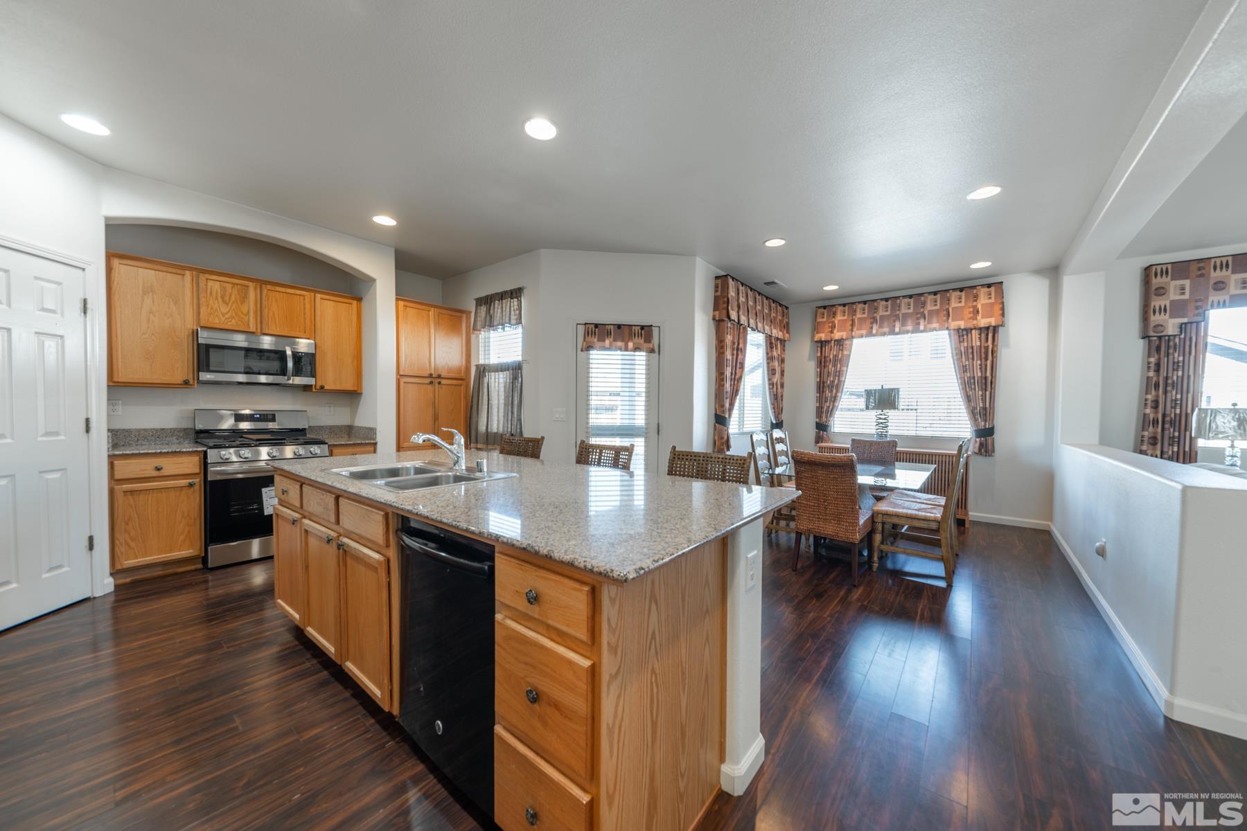1413 Wild Wolf Way Reno, NV 89521 - Photo 19 of 40 a kitchen with stainless steel appliances granite countertop wooden floors and sink