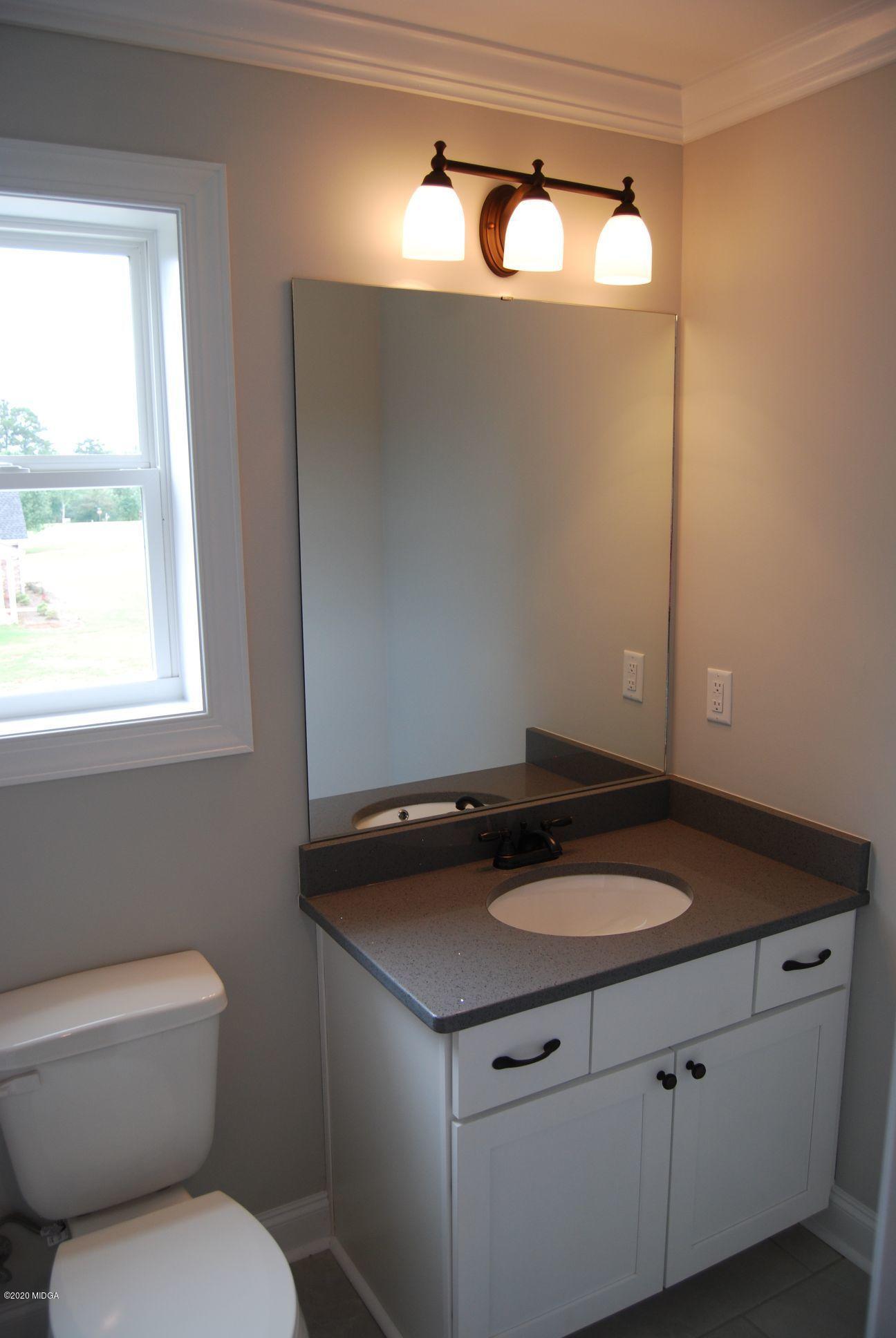 65 Carters Way Forsyth, GA 31029 - Photo 13 of 13 a bathroom with a granite countertop sink and a toilet