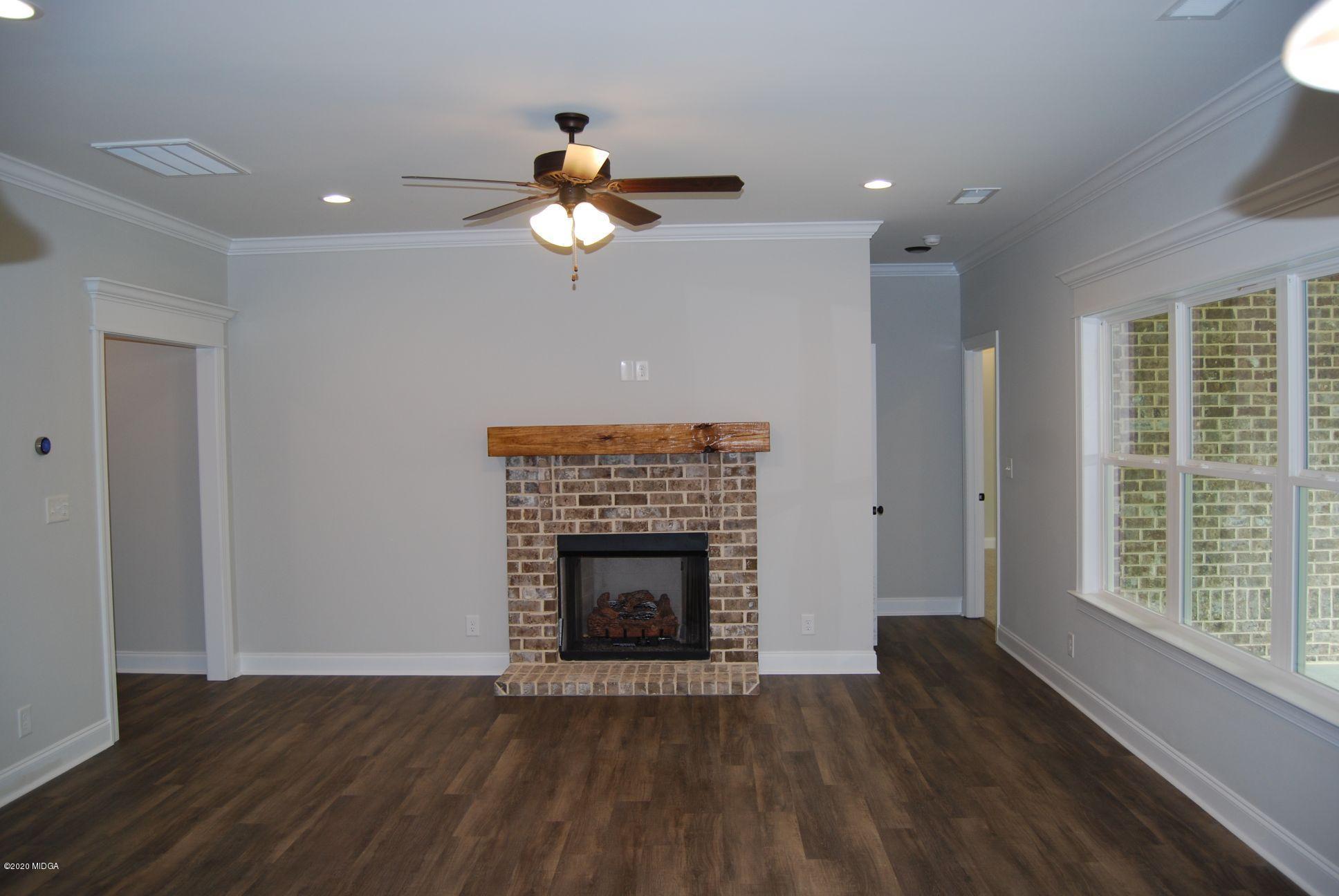 65 Carters Way Forsyth, GA 31029 - Photo 3 of 13 a view of an empty room with wooden floor and a fireplace