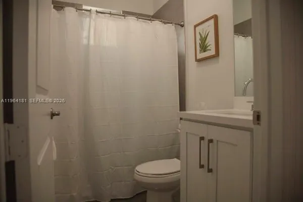 a bathroom with a shower curtain and a toilet