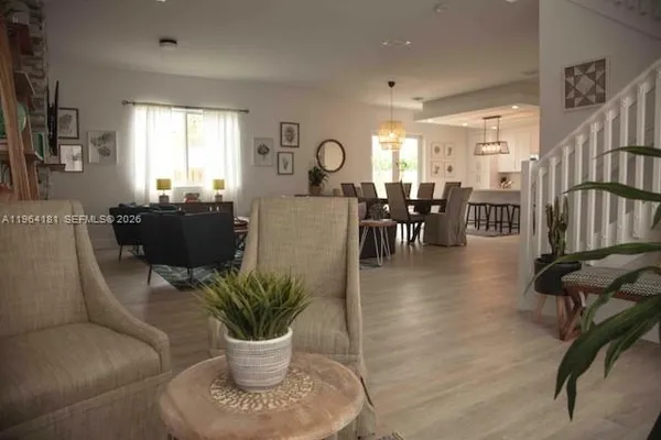 a living room with furniture a dining table and a potted plant