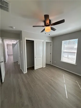 an empty room with windows and fan