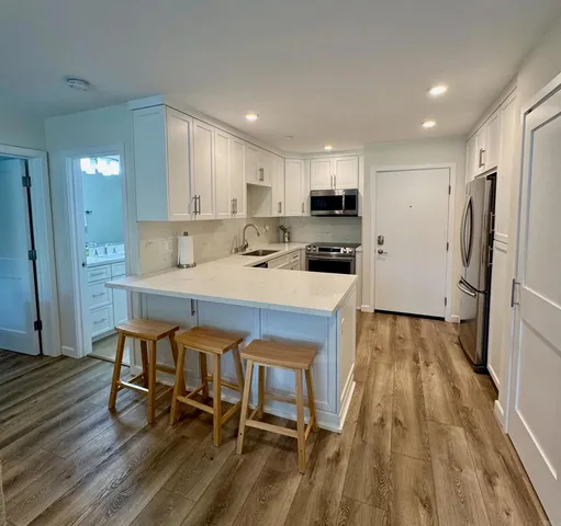 a kitchen with a table chairs refrigerator and microwave