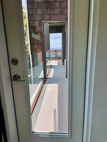 a view of a hallway with wooden floor and stairs
