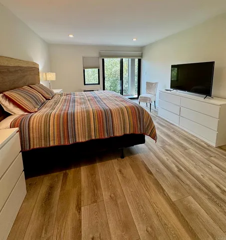 a bed sitting in a bedroom next to a flat tv screen and a dresser