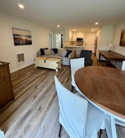 a living room with furniture flat screen tv and kitchen view