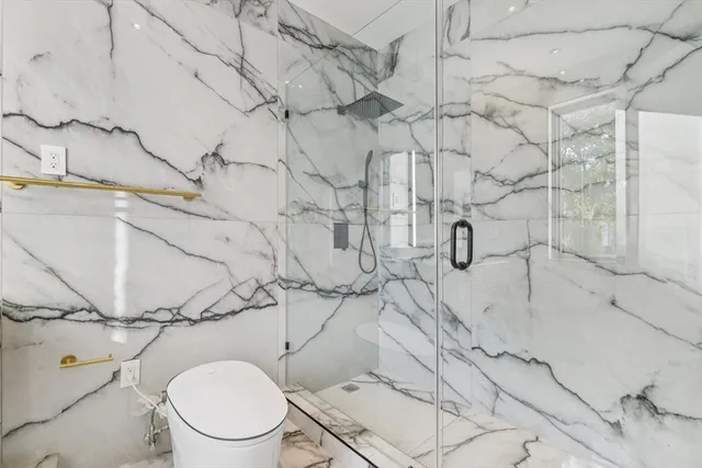 a white toilet sitting next to a shower